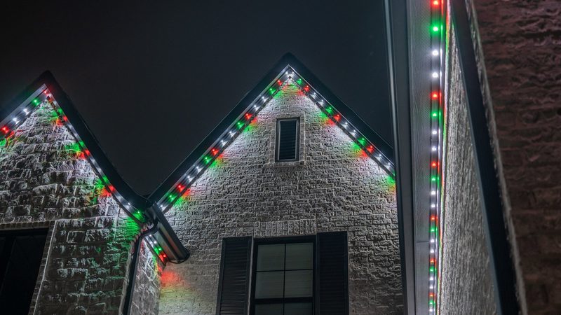 A brick home lit in red and white
